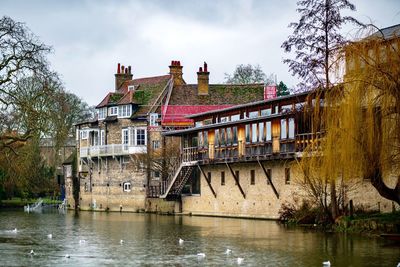 Built structure by river against sky