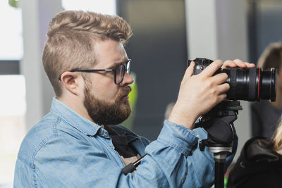 Side view of man photographing with camera