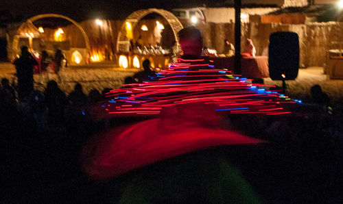 Rear view of people on illuminated stage at night