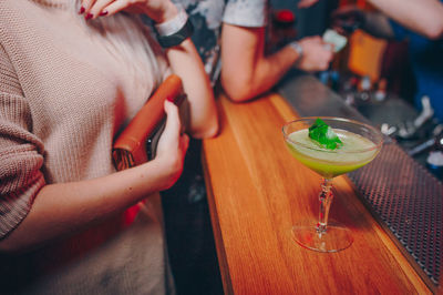 Close-up of drinks on table with people on background