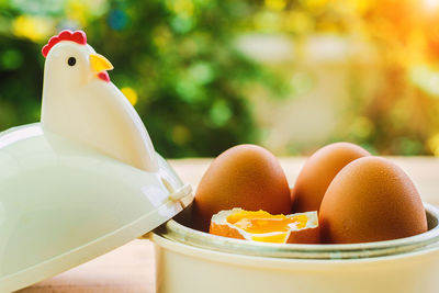 Close-up of boiled eggs in chicken shape container on table