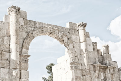 Low angle view of old ruin building against cloudy sky