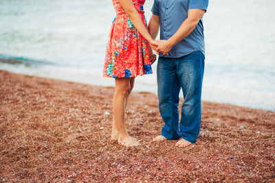 Low section of women standing on beach