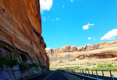 Road amidst rock formation against sky