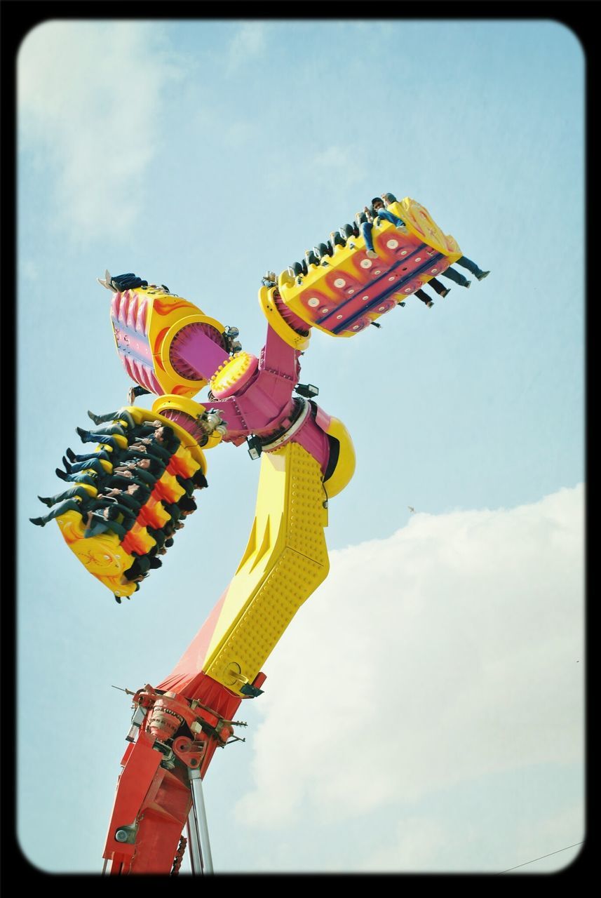 low angle view, transfer print, sky, amusement park, auto post production filter, arts culture and entertainment, amusement park ride, fun, multi colored, flag, yellow, outdoors, blue, day, cloud, cloud - sky, leisure activity, enjoyment, clear sky, art and craft