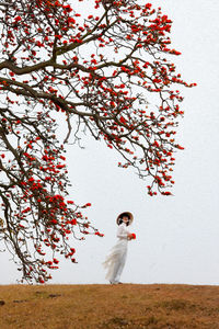 Person standing by tree on field