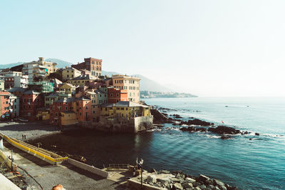 Scenic view of sea by buildings against clear sky