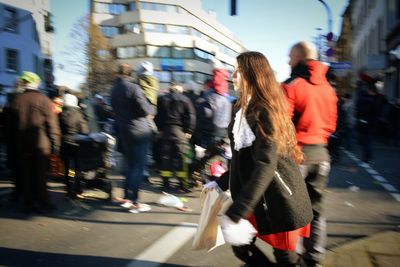 Blurred motion of people walking on road in city