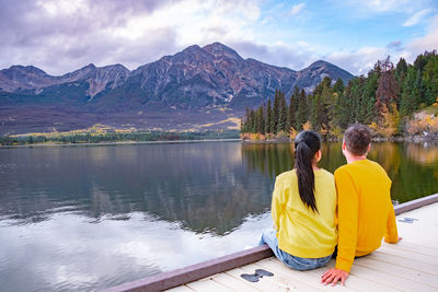 Rear view of women on lake against mountain range