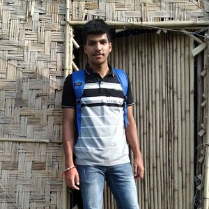 Portrait of young man standing outside hut