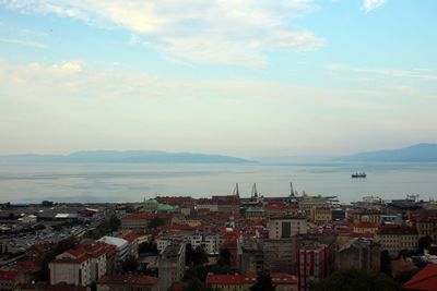 High angle view of townscape by sea against sky
