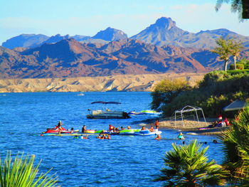 People on boat in mountains against sky