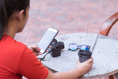 Rear view of woman photographing with mobile phone