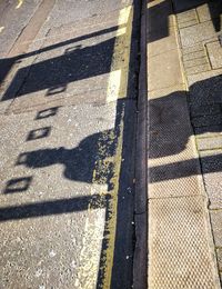 High angle view of yellow shadow on road