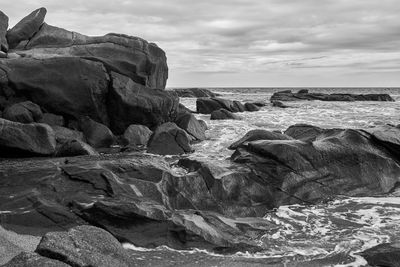 Rocks on beach against sky