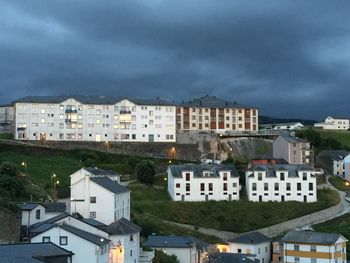 Buildings against cloudy sky at dusk