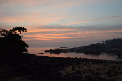Scenic view of beach against sky during sunset