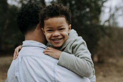 Portrait of happy boy with baby outdoors