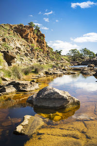 Rock formation in water against sky