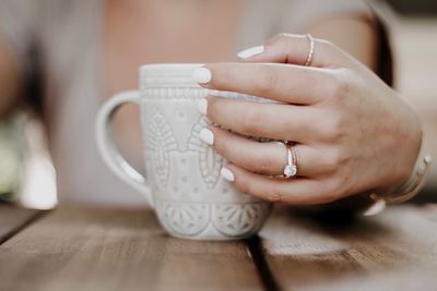 Woman holding coffee cup on table