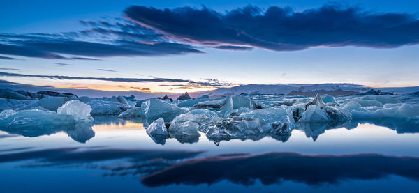 Scenic view of frozen lake against sky during sunset