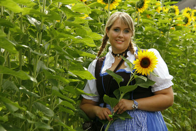 Portrait of smiling woman with yellow flowers