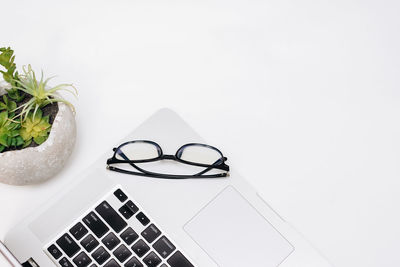 Close-up of eyeglasses on table against white background