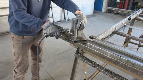 Low section of man welding in factory