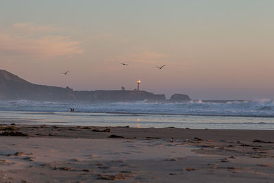 Scenic view of beach against sky during sunset