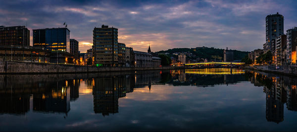 Reflection of buildings in lake at sunset