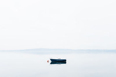 Scenic view of lake and a boat against sky