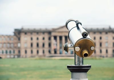 Close-up of coin-operated binoculars against sky