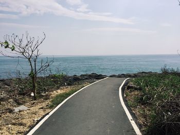 Empty road along calm sea