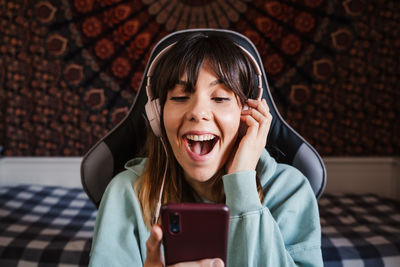 Smiling young woman video conferencing over mobile phone