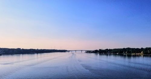 Scenic view of lake against clear sky at sunset