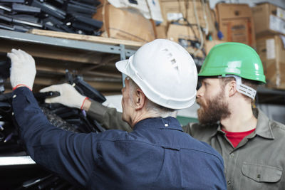 Workers in computer recycling plant searching for keyboards