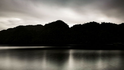 Reflection of trees on water against sky