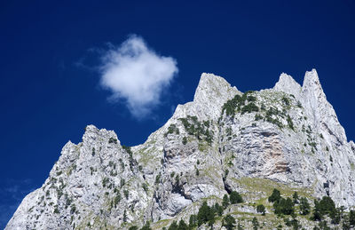 Low angle view of rocks against blue sky