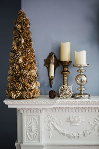 Christmas decoration and candles on mantelpiece