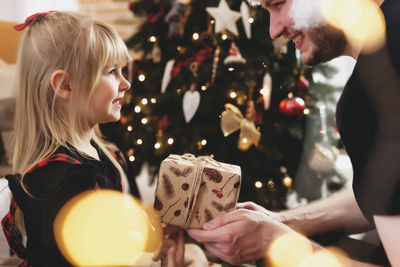 Rear view of a girl holding christmas tree