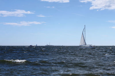 Sailboat sailing in sea against sky