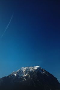 Low angle view of snowcapped mountain against sky