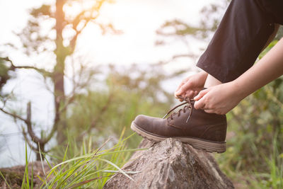 Two woman hands lacing up trekking shoes