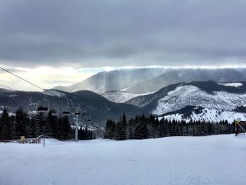Scenic view of snow covered mountains against sky