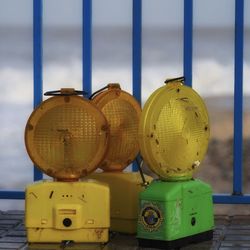 Close-up of yellow metallic structure by sea against sky