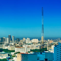 Buildings in city against clear blue sky