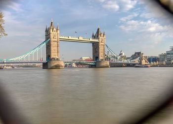 View of bridge over river against cloudy sky