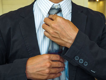 Midsection of man holding umbrella