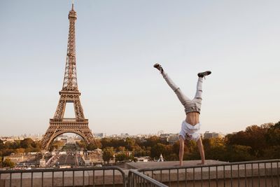 Man doing handstand against eiffel tower