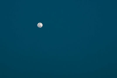 Low angle view of moon against blue sky